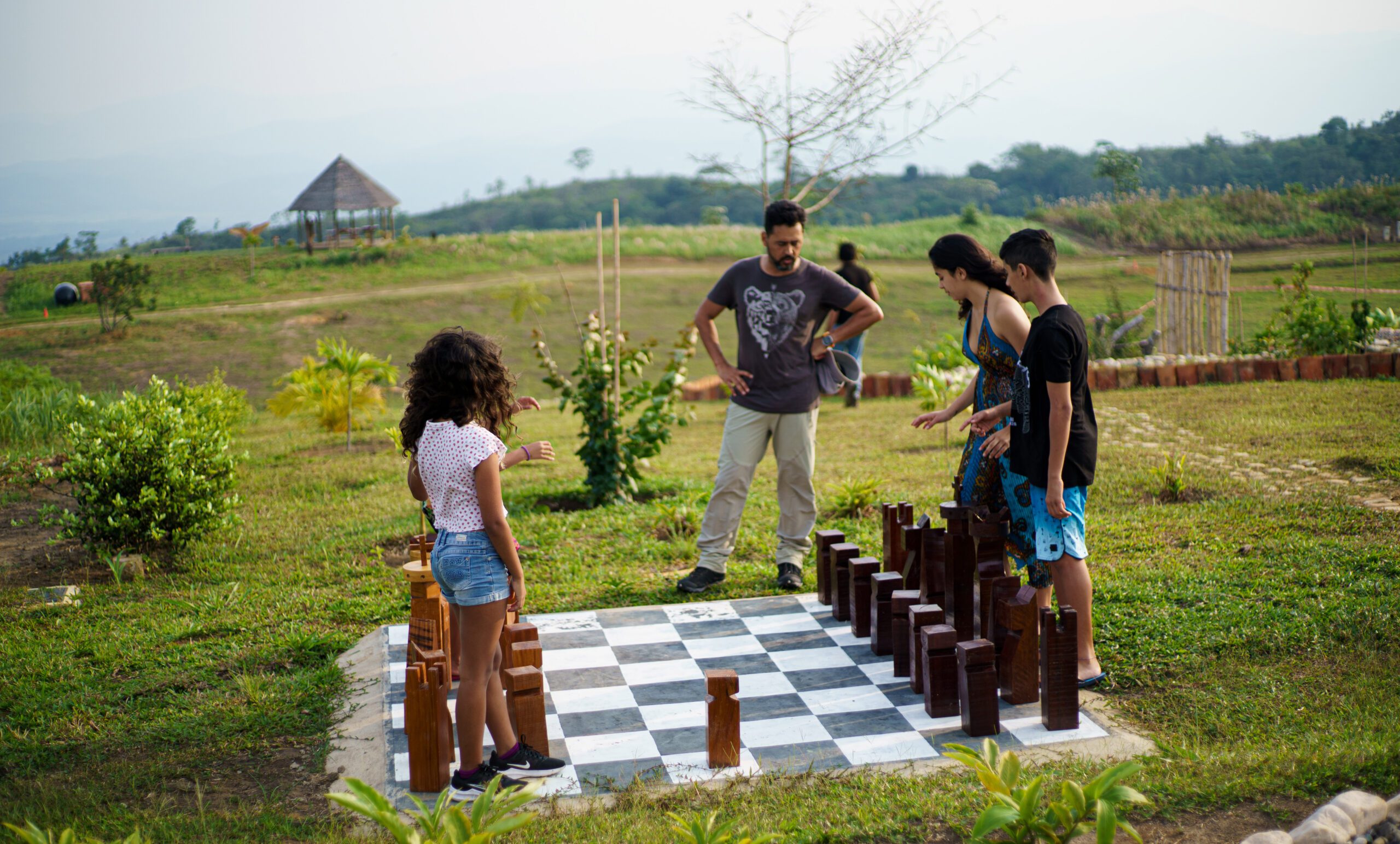 Familia jugando al ajedrez gigante al aire libre en la zona parque del condominio estilo resort Yanashpa Village en Tarapoto