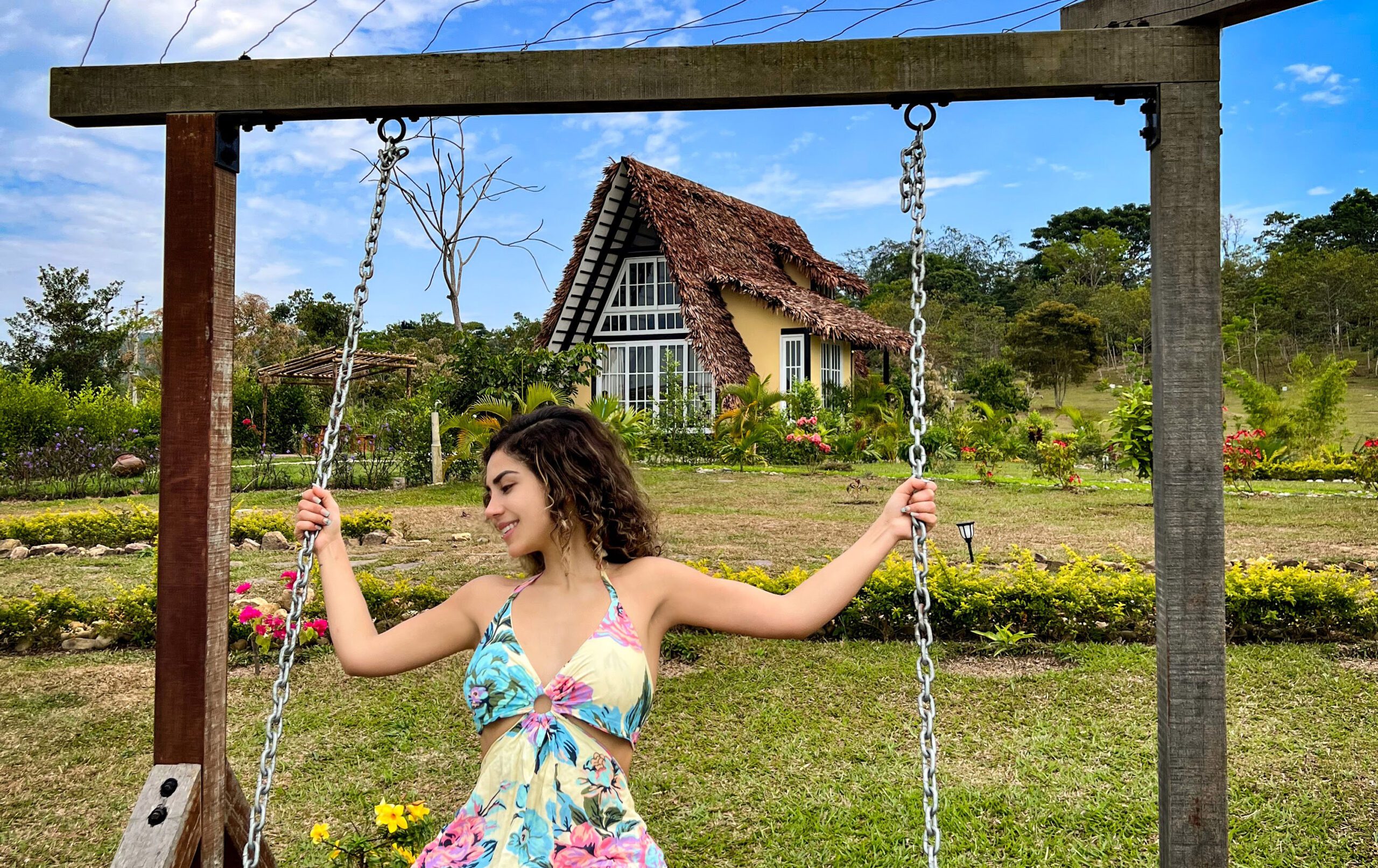 Blogera Veggie Viajera disfrutando de un columpio frente a una casa A frame y conectándose con lo esencial de la naturaleza en Yanashpa Villlage, Tarapoto